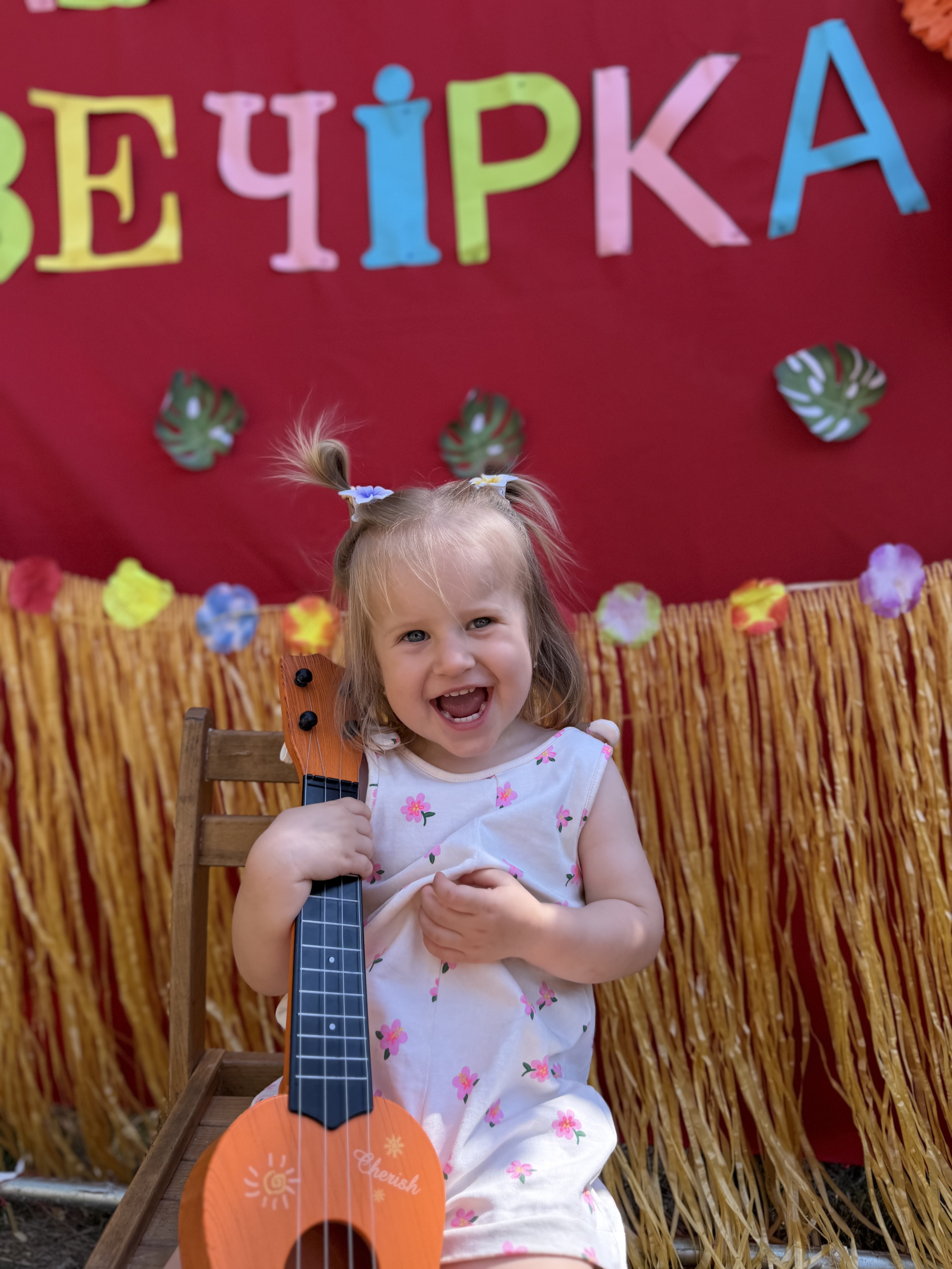 Усміхнена вихованка НВК «Гармонія» з дитячою гітарою